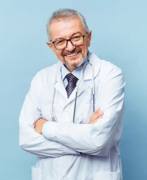 Médecin d'un certain âge souriant les bras croisés