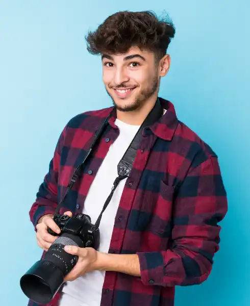 Jeune homme photographe tenant son appareil photo