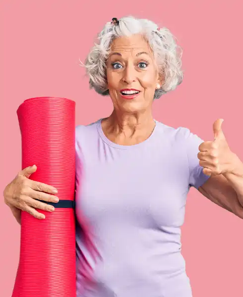 Femme âgée dynamique tenant son tapis de yoga