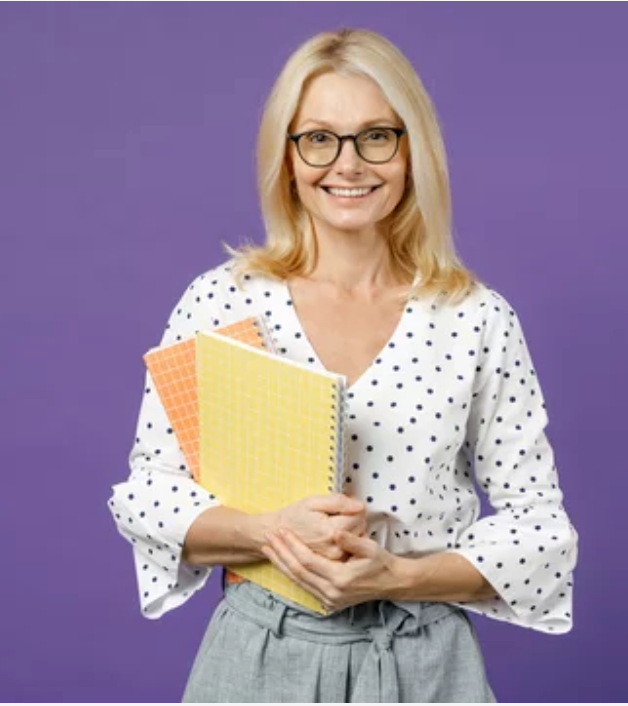 Directrice d'une école élémentaire privée posant, souriante avec des cahiers dans les bras